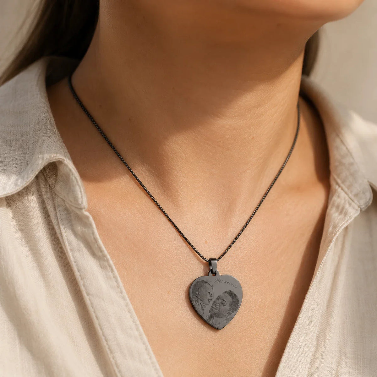 Pendentif cœur noir gravé porté en collier, chemise beige
