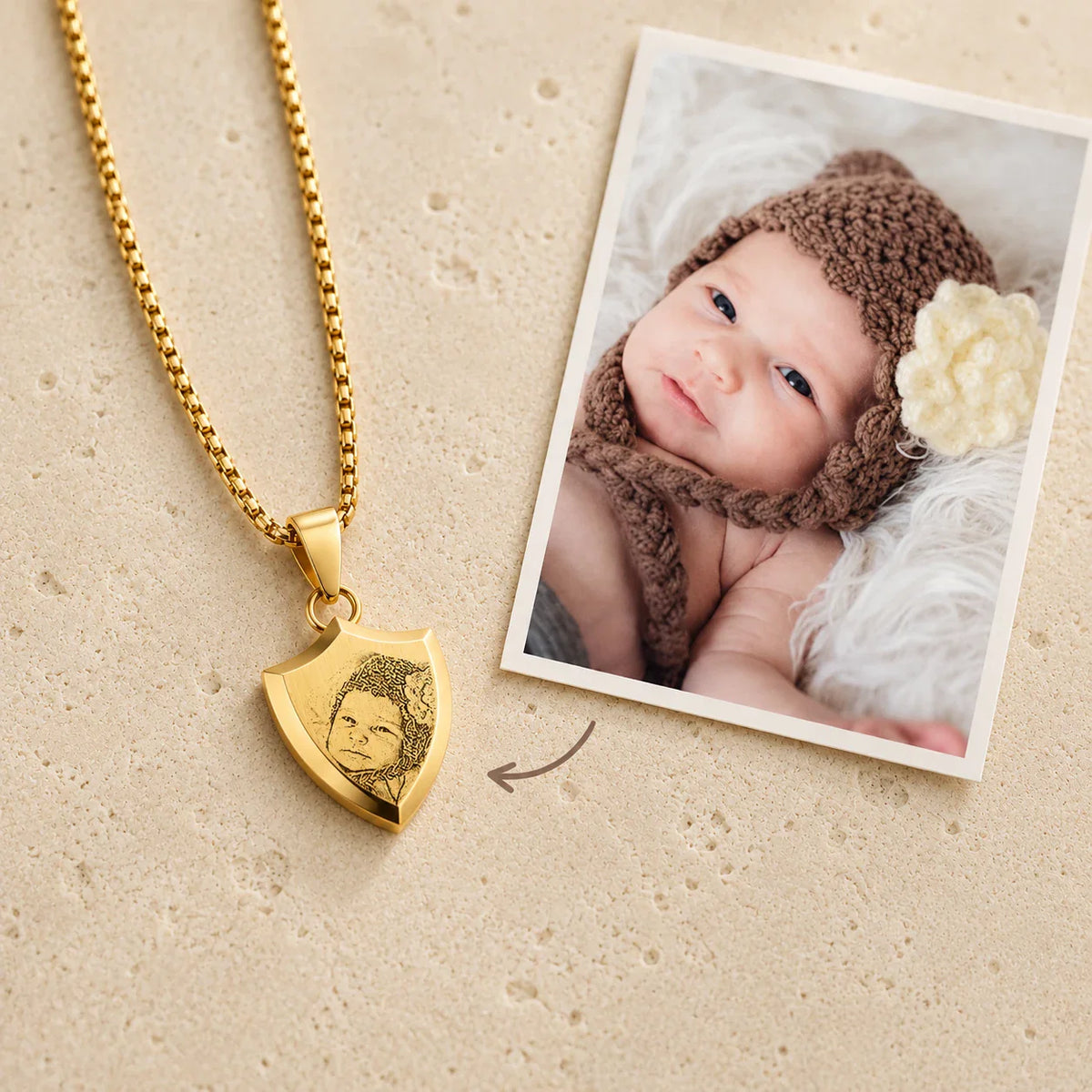 Pendentif écusson personnalisé byLivia en doré, portrait de bébé gravé, à côté de la photo d'origine